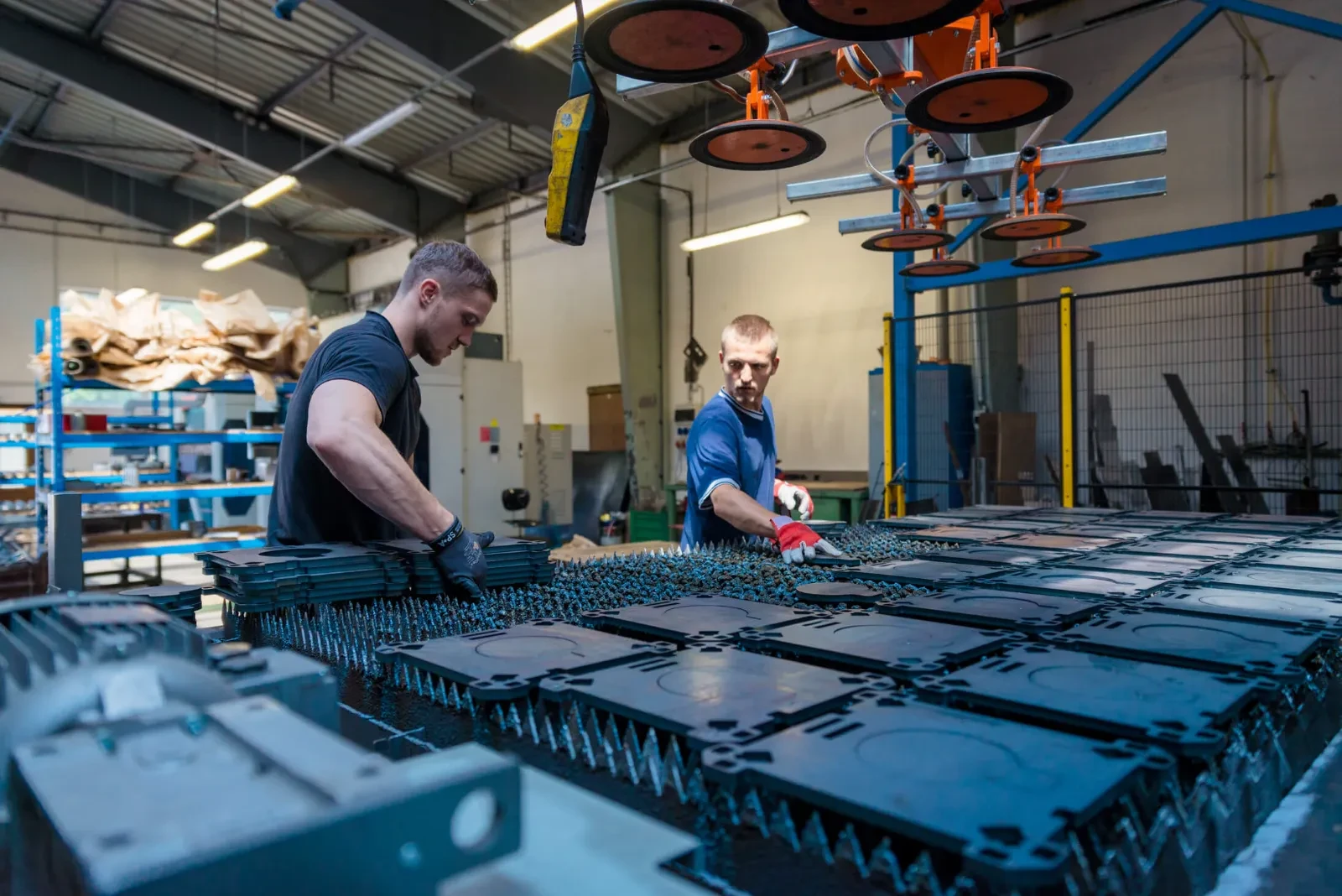 Dva pracovníci u stolu laseru s vyřezanými díly