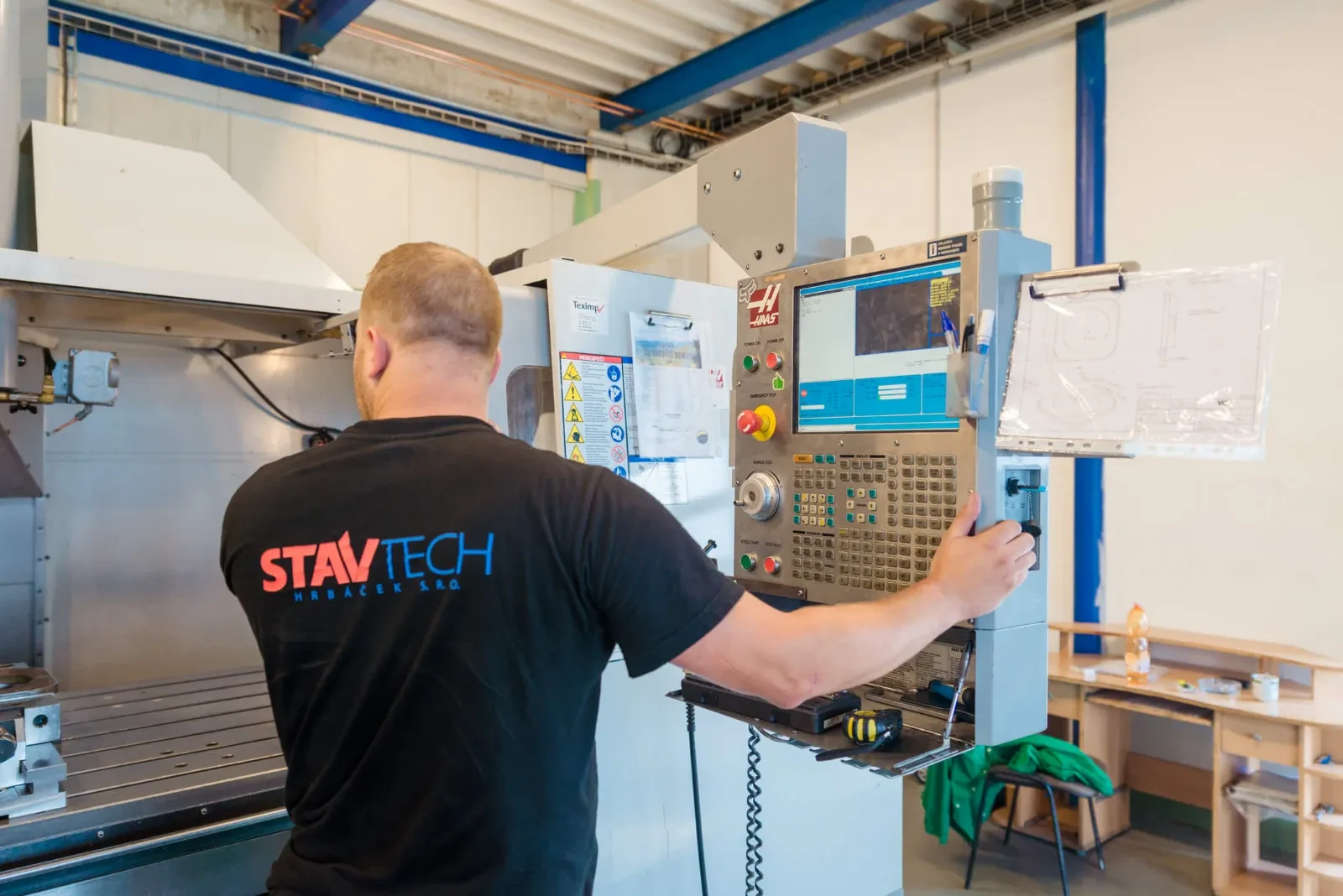 An operator at the control panel of the HAAS machining center